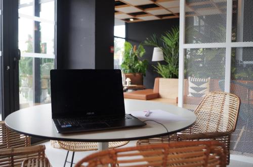 a laptop sitting on a table with chairs at Ibis Lunel Petite Camargue in Lunel