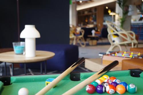 a pool table with three bats and balls on it at Ibis Lunel Petite Camargue in Lunel