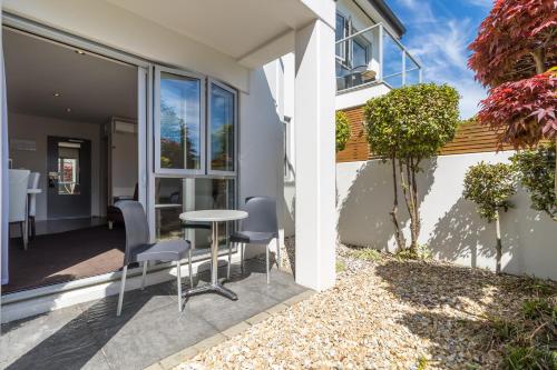 a patio with a table and chairs outside of a house at Century Park in Nelson