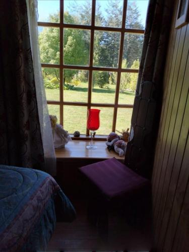 a bedroom with a window and a desk with a red lamp at Cabañas Noche Estrellada Pucón in Pucón