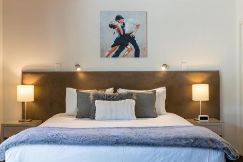 a bedroom with a large bed with two lamps at Century Park in Nelson