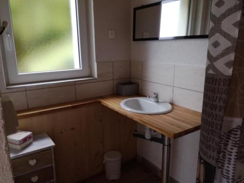 a bathroom with a sink and a window at Gîte Le p'tit Chasseral in Maîche