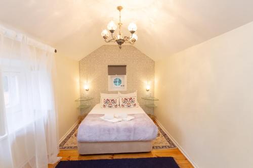 a bedroom with a bed and a chandelier at Quinta Das Murtas B&B in Sintra