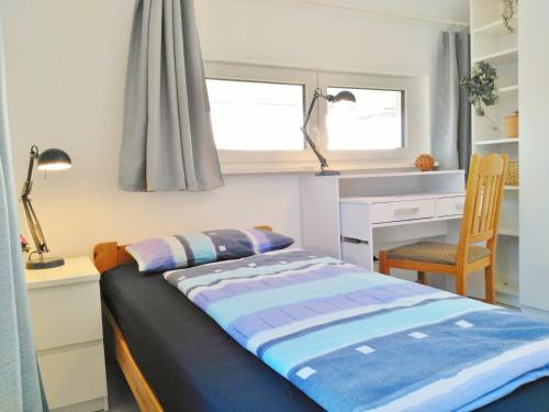 Schlafzimmer mit einem Bett, einem Schreibtisch und einem Stuhl in der Unterkunft FeWo ODEM in Gladenbach