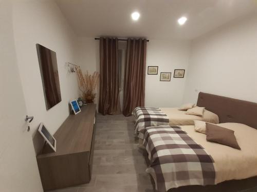 1 dormitorio con 2 camas y escritorio con espejo en Casa Calù, en Génova