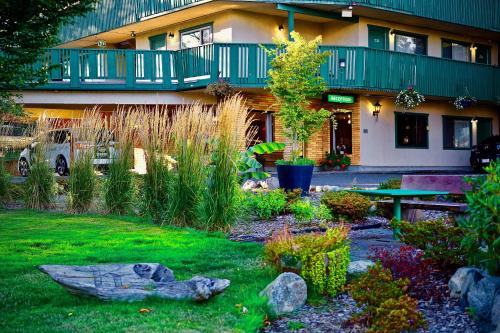 un jardin en face d'un bâtiment dans l'établissement Robin Hood Inn and Suites, à Victoria