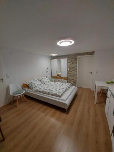 1 dormitorio con 1 cama grande en una habitación con suelo de madera en Lavendel Apartment en Riederich