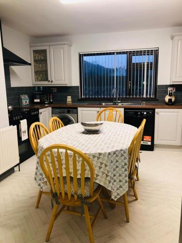 a kitchen with a table and chairs in a kitchen at Littles Cottage, heart of the Mournes in Annalong