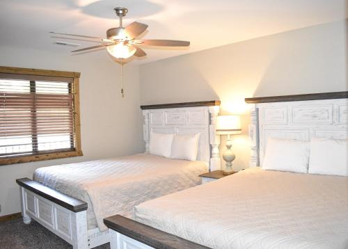 a bedroom with two beds and a ceiling fan at Table Rock Resorts at Indian Point in Branson