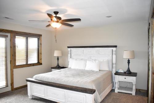 a bedroom with a white bed with a ceiling fan at Table Rock Resorts at Indian Point in Branson