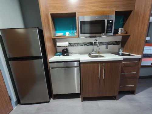 a small kitchen with a sink and a refrigerator at La Quinta Inn & Suites by Wyndham Fort Stockton Northeast in Fort Stockton