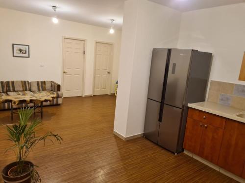 a kitchen with a stainless steel refrigerator in a living room at נוף הרים Mountain View in Neve Daniel