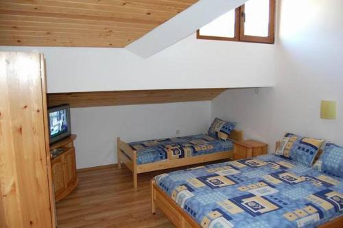 1 dormitorio con 2 camas y TV. en Guest Rooms Toni & Miro, en Tryavna