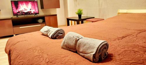 ein Hotelzimmer mit einem Bett mit Handtüchern darauf in der Unterkunft M&M Apartment VIII Self CHECK-IN in Panevėžys