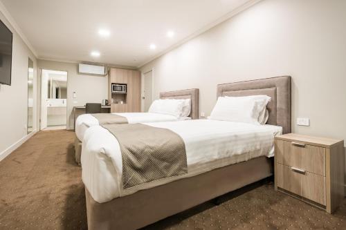 a hotel room with two beds and a kitchen at The Lighthouse Hotel in Ulverstone