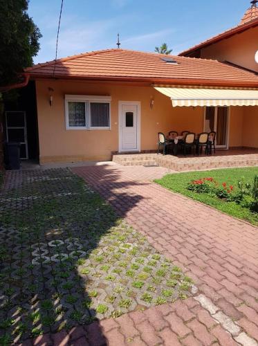 a house with a brick walkway and a patio at Szetti Nyaraló in Balatonszárszó