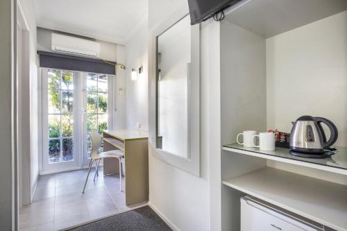 a kitchen with a counter and a table with a kettle at Nightcap at Skyways Hotel in Melbourne