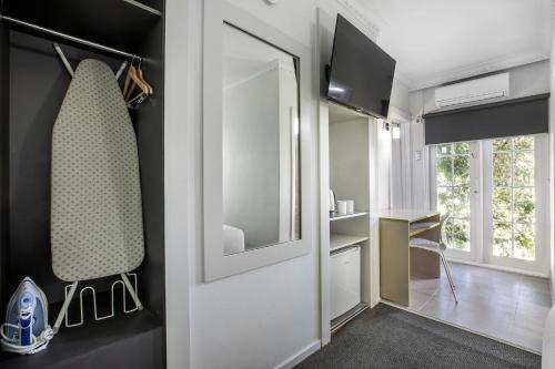 a room with a door with a mirror and a desk at Nightcap at Skyways Hotel in Melbourne