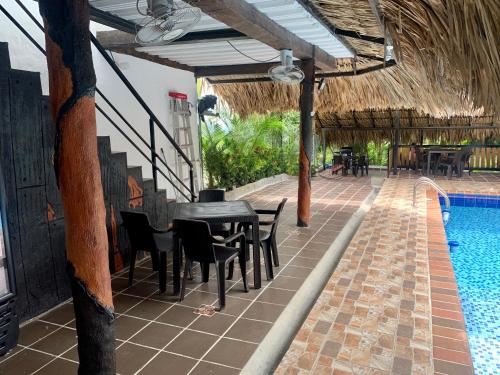 a patio with a table and chairs next to a swimming pool at Cabaña hotel conde in Doradal