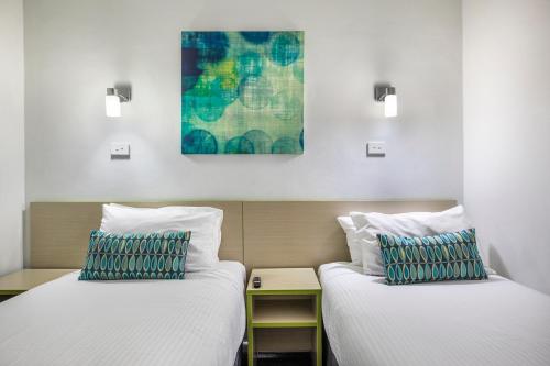 two beds sitting next to each other in a room at Nightcap at Skyways Hotel in Melbourne