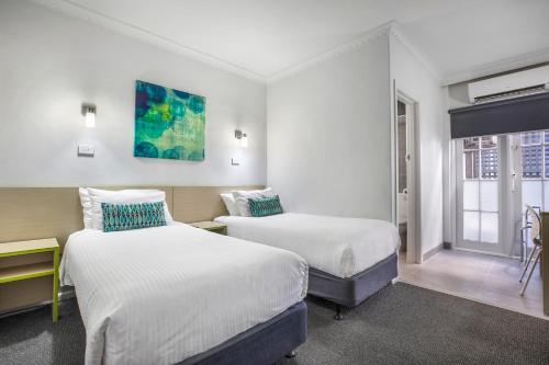 a hotel room with two beds and a window at Nightcap at Skyways Hotel in Melbourne