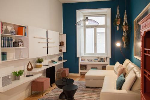 a living room with blue walls and a white couch at FLH Chiado Nature Apartment in Lisbon