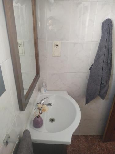 y baño con lavabo blanco y espejo. en CASA RURAL AGUA AGRIA, en Pórtugos