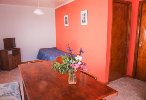 een kamer met een tafel met een vaas met bloemen erop bij Casa en Claromecó La Alegria in Balneario Claromecó