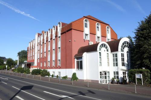 un edificio rojo y blanco al lado de una carretera en Best Western Hotel Rosenau en Bad Nauheim