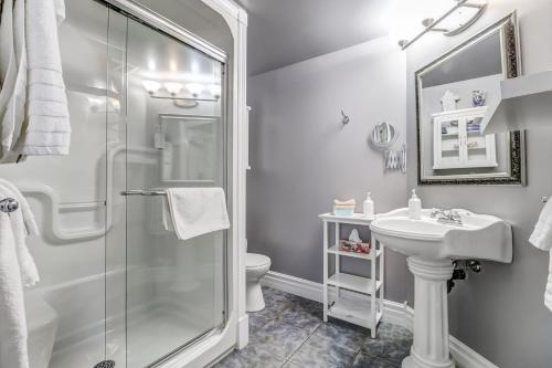 a white bathroom with a shower and a sink at School House Bed and Breakfast C.1859 in Niagara on the Lake