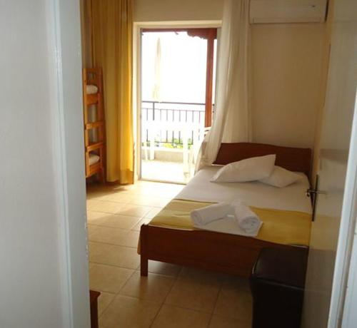 a bedroom with a bed with two towels on it at Harilaos Beach in Plaka Litochorou