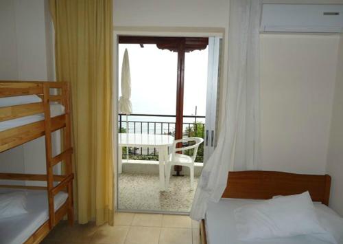 a bedroom with a bed and a balcony with a view at Harilaos Beach in Plaka Litochorou