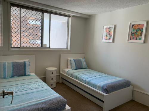 um quarto com 2 camas e uma janela em Linden Court Broadbeach em Gold Coast