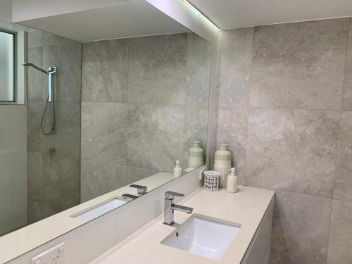 uma casa de banho com um lavatório e um espelho em Linden Court Broadbeach em Gold Coast