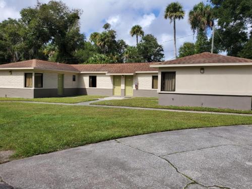 a home in a subdivision with palm trees at Travel Inn Daytona in Daytona Beach