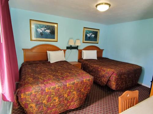 a hotel room with two beds in a room at Travel Inn Daytona in Daytona Beach
