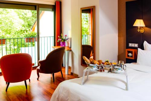 a hotel room with a bed with a tray of food on it at Logis Hôtel La Brèche de Roland in Gèdre