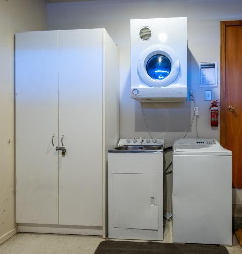 a room with a washing machine and a tv on the wall at *** LAKE VILLA 465 *** in Hanmer Springs