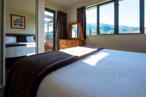 a bedroom with a bed and a large window at *** LAKE VILLA 466 *** in Hanmer Springs