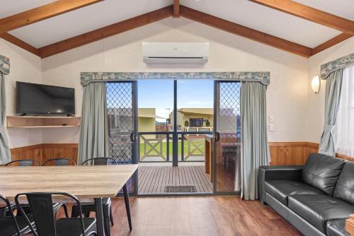 a living room with a couch and a table at Discovery Parks - Adelaide Beachfront in Adelaide