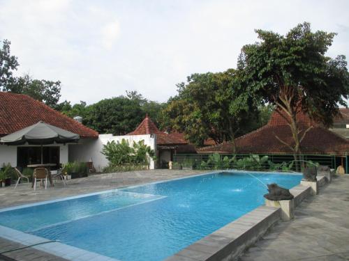 - une piscine en face d'une maison dans l'établissement Alam Jogja Resort Mitra RedDoorz, à Yogyakarta