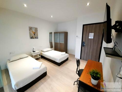 a hotel room with two beds and a desk at International Service Apartments at Raeburn Park in Singapore