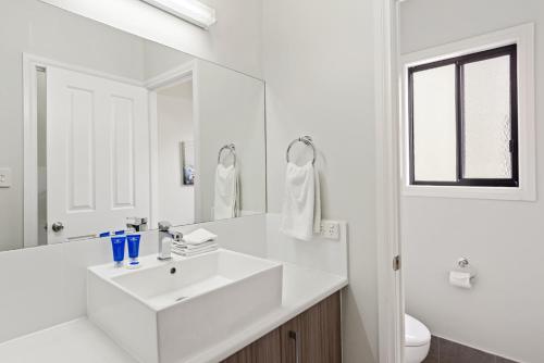 
a bathroom with a sink, mirror, and bathtub at Discovery Parks - Adelaide Beachfront in Adelaide
