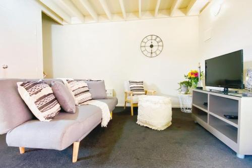 a living room with a couch and a tv at Hideaway Rima - in the CBD in Queenstown
