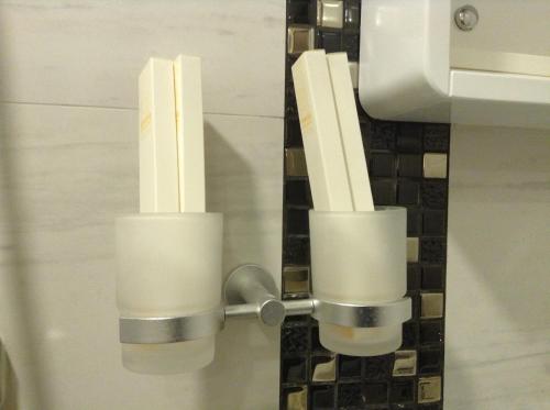 un par de candelabros en un dispensador de papel higiénico en California Hotel, en Hong Kong