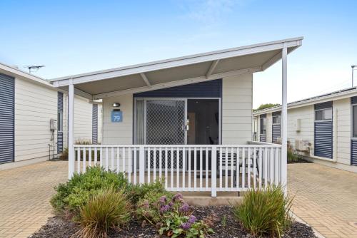 a house with a porch with a white fence at Discovery Parks - Adelaide Beachfront in Adelaide