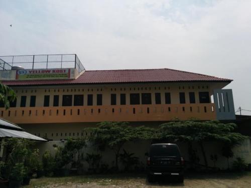 a building with a van parked in front of it at Yellow House in Sunggal