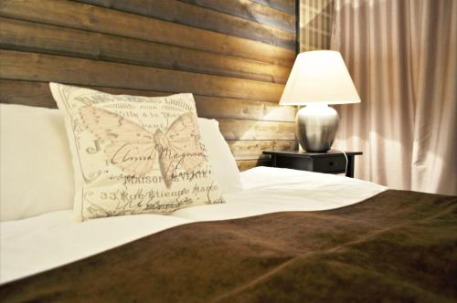 a bed with a pillow and a lamp on a table at Jennys Hotell och Restaurang in Arvika