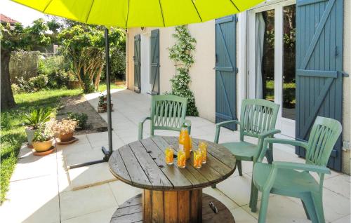 ein Tisch mit Stühlen und einem Sonnenschirm auf einer Terrasse in der Unterkunft Beautiful Home In Nissan Lez Enserune in Nissan-lez-Enserune
