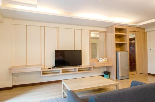 a living room with a tv and a table at Tara Lake in Bangkok